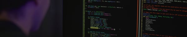 National Cybersecurity Testing Institute video fallback, person in front of monitor with code