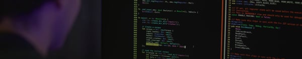National Cybersecurity Testing Institute video fallback, person in front of monitor with code